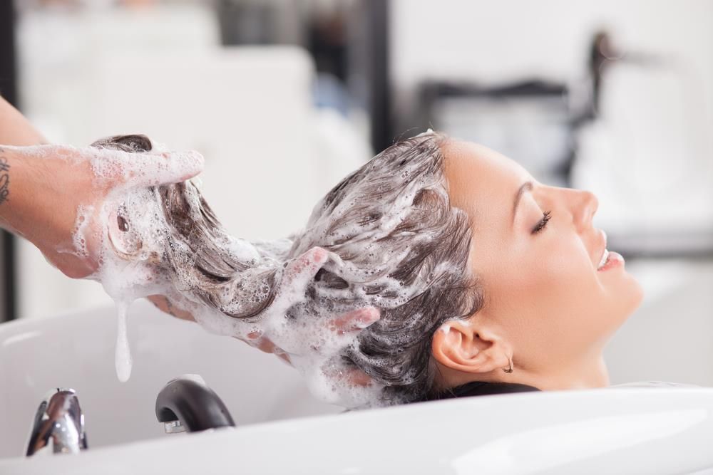 woman shampooing her hair at salon